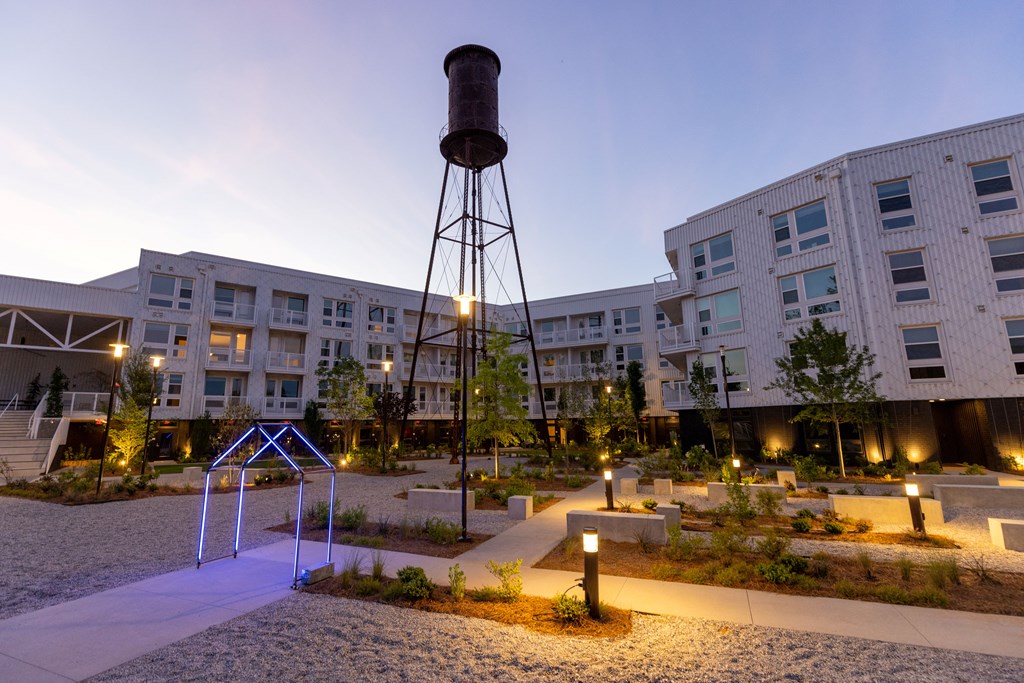 a water tower sits in the middle of a courtyard at night