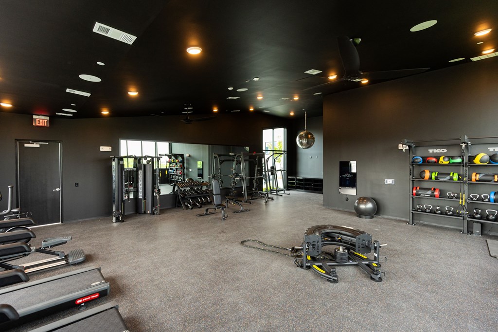 a workout room with weights and cardio equipment in a gym