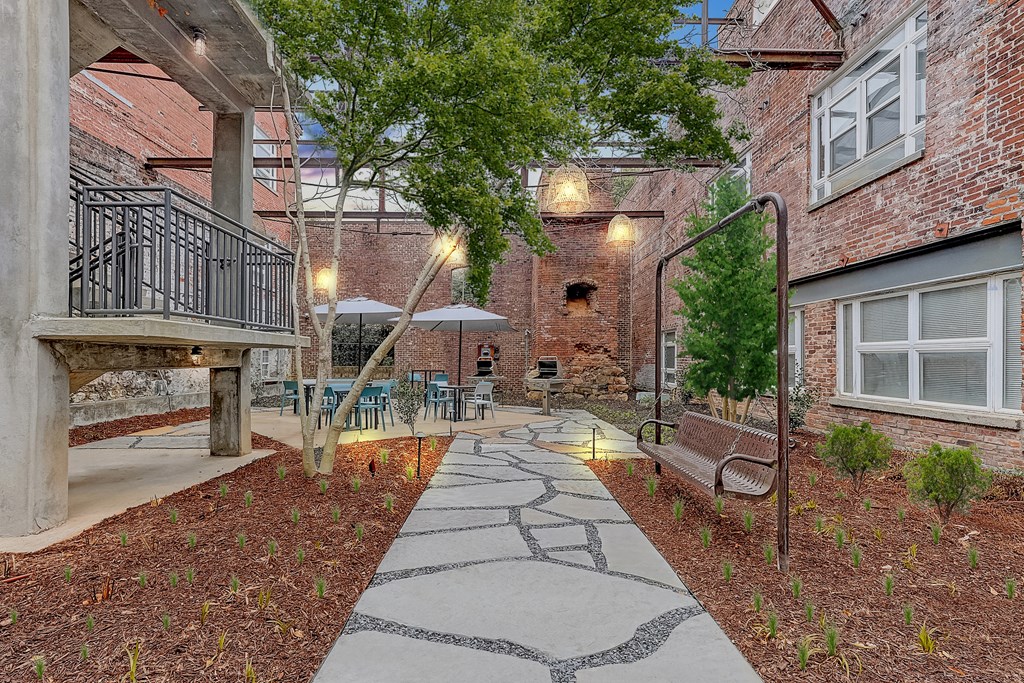 a courtyard with a stone walkway and a bench