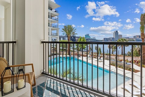 A balcony with a pool and a view of the city.