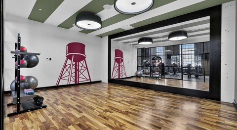 A gym with wooden floors and red chairs.
