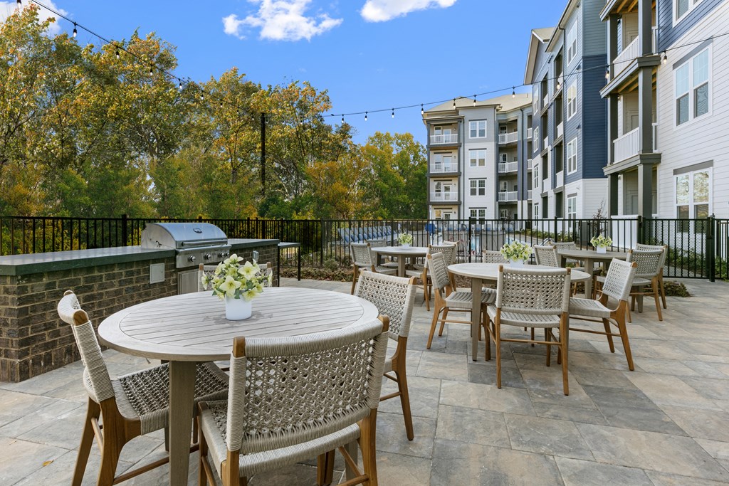 an outdoor patio with tables and chairs at an apartment complex