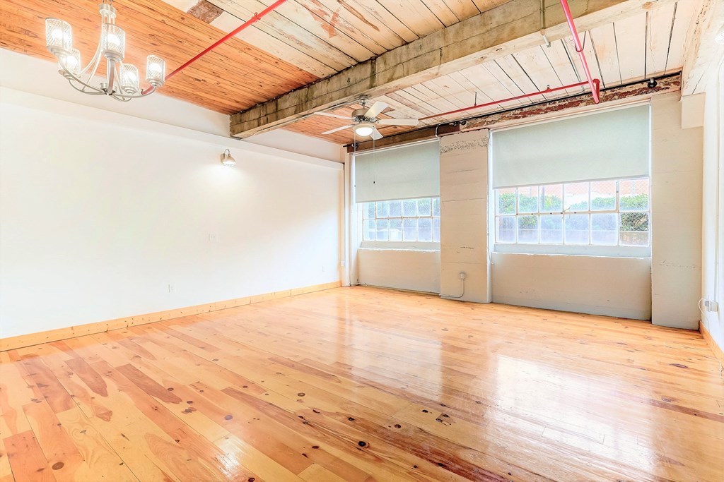 an empty room with white walls and wood floors