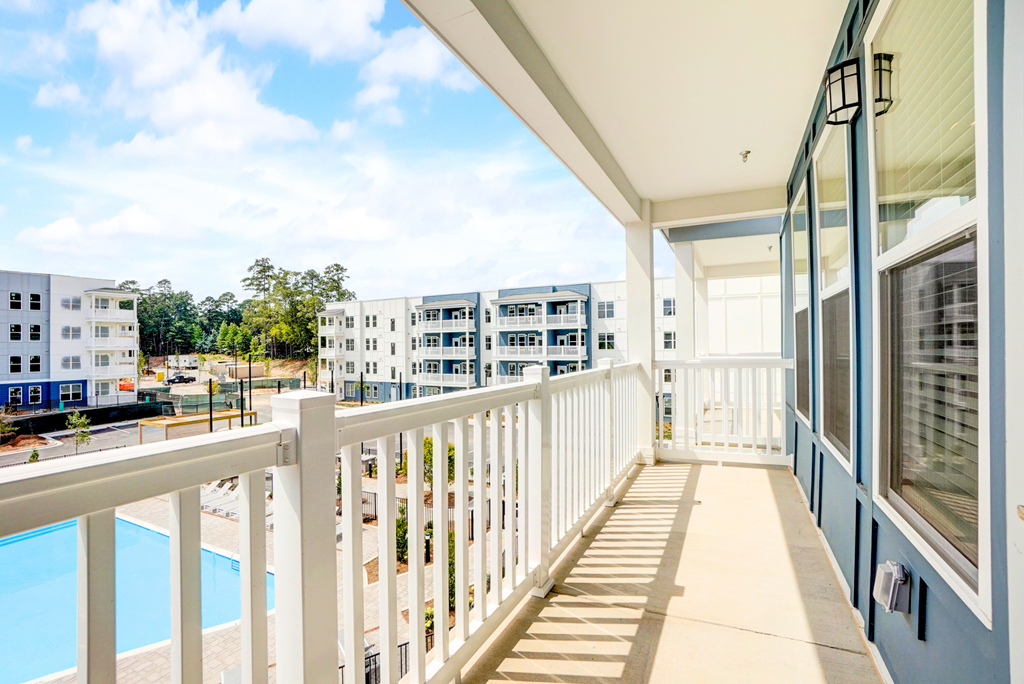 a balcony with a view of a pool and apartment buildings