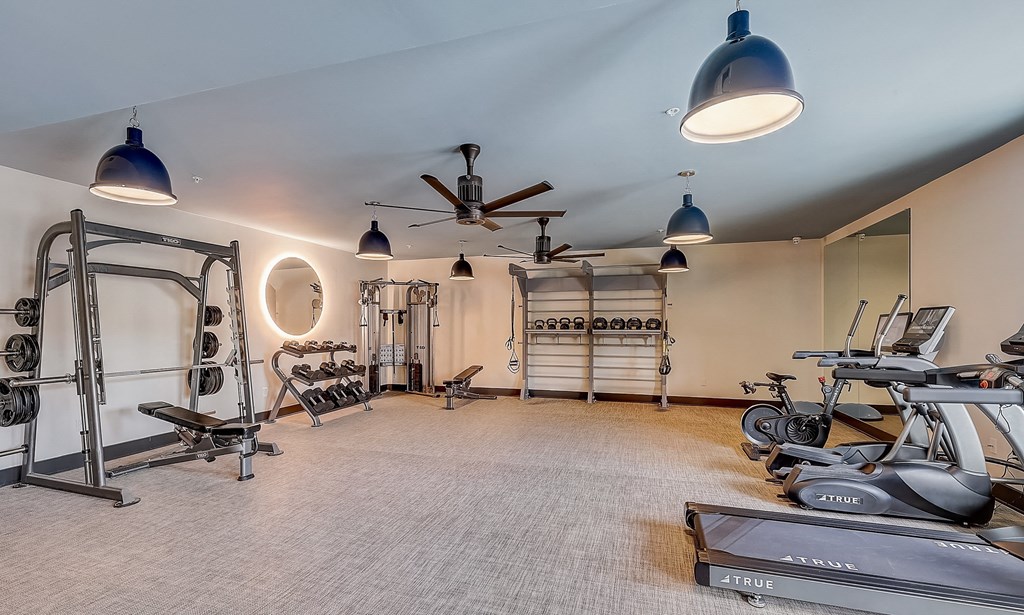 a home gym with exercise equipment and a ceiling fan