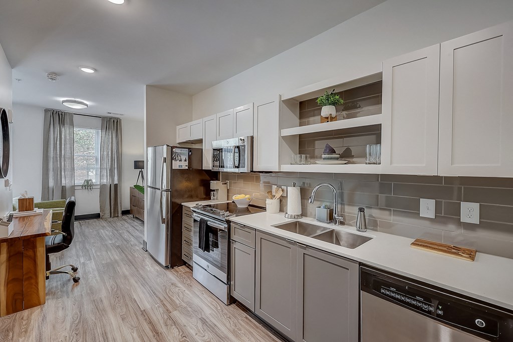a kitchen with white cabinets and stainless steel appliances