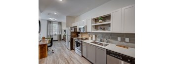a kitchen with white cabinets and stainless steel appliances