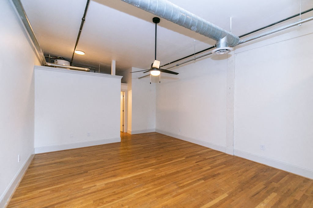 a living room with a wood floor and white walls