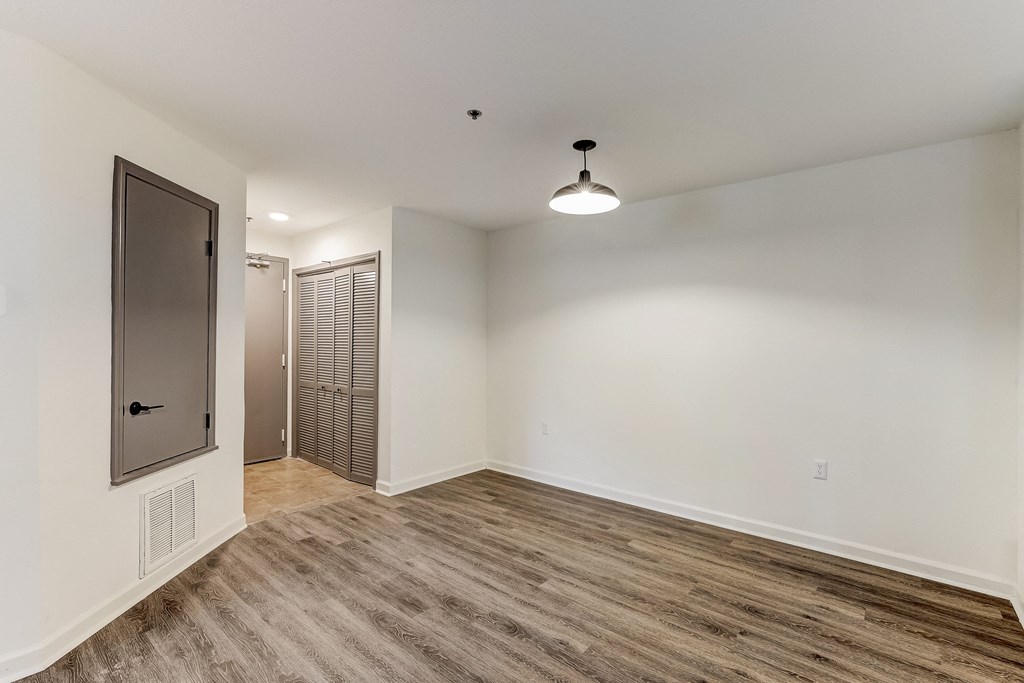 a bedroom with hardwood flooring and white walls