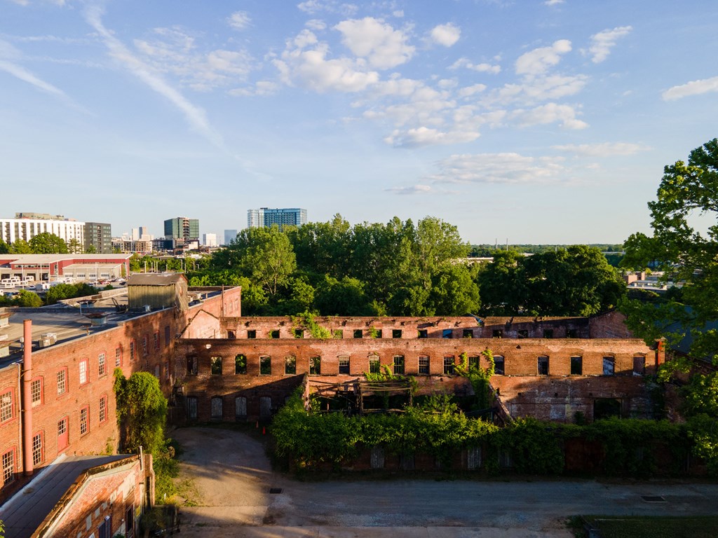 an aerial view of an old brick building with a city in the background