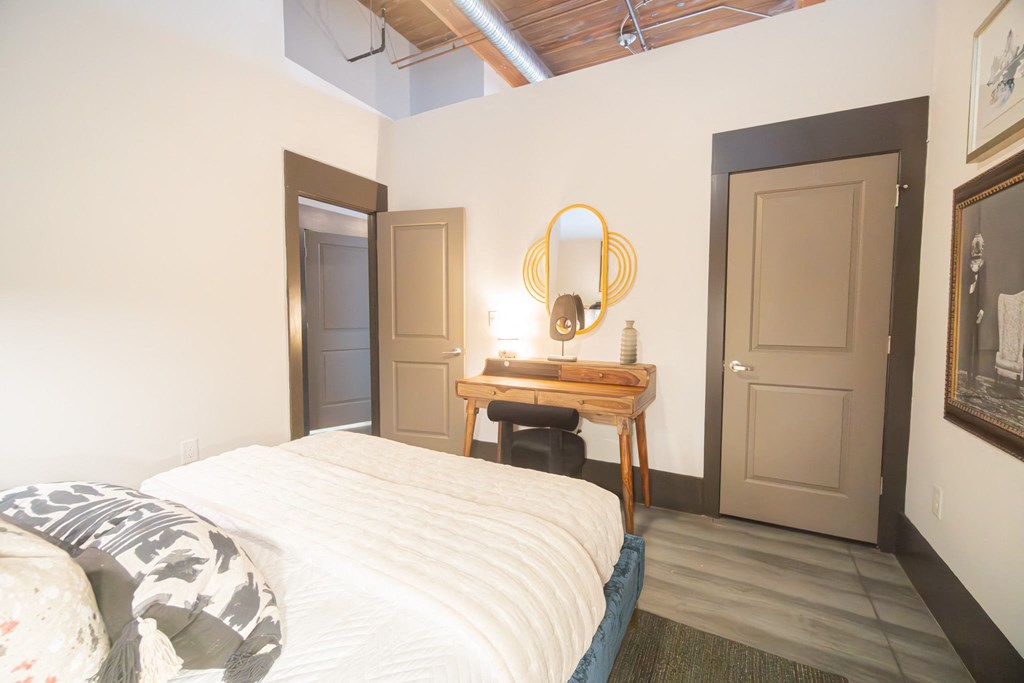 a bedroom with a bed and a desk with a mirror