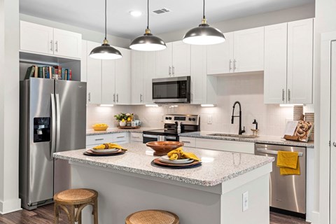 a kitchen with white cabinets and stainless steel appliances