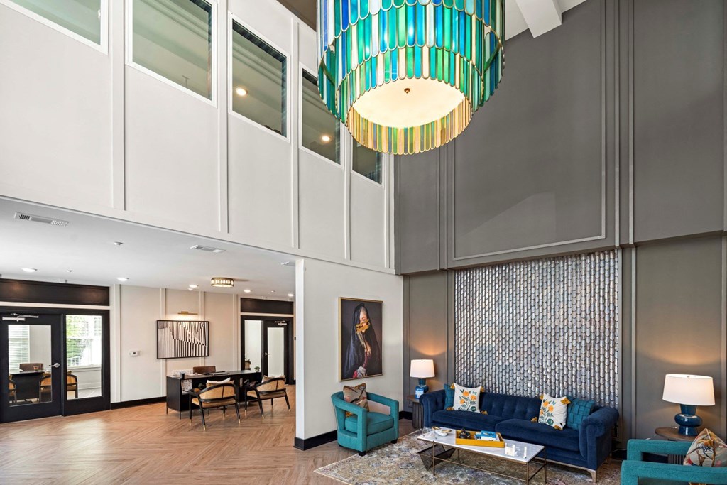 a living room with blue couches and a large chandelier