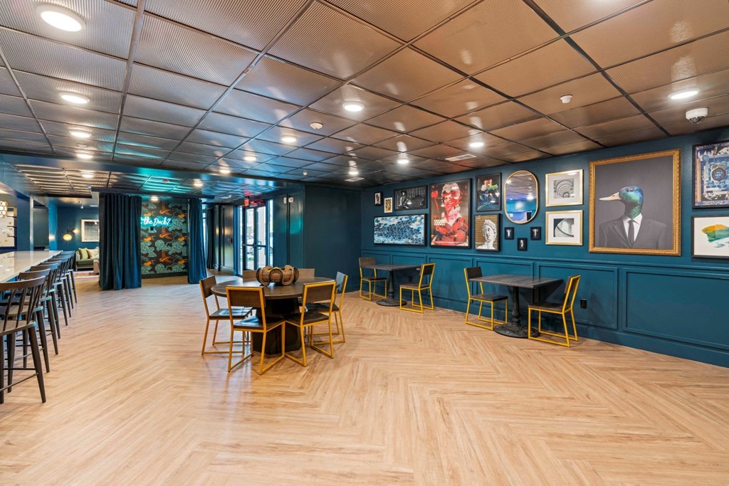 a dining room with blue walls and a wooden floor and tables and chairs