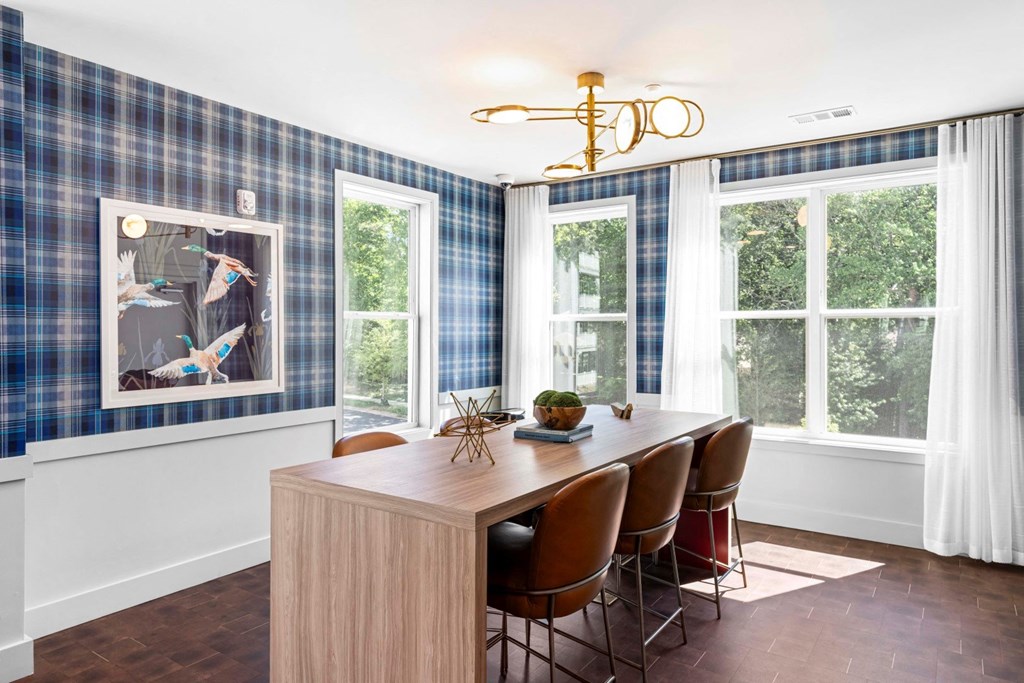 a dining room with a wooden table and chairs and a large window