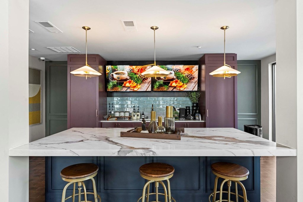 a kitchen with a marble counter top and three stools