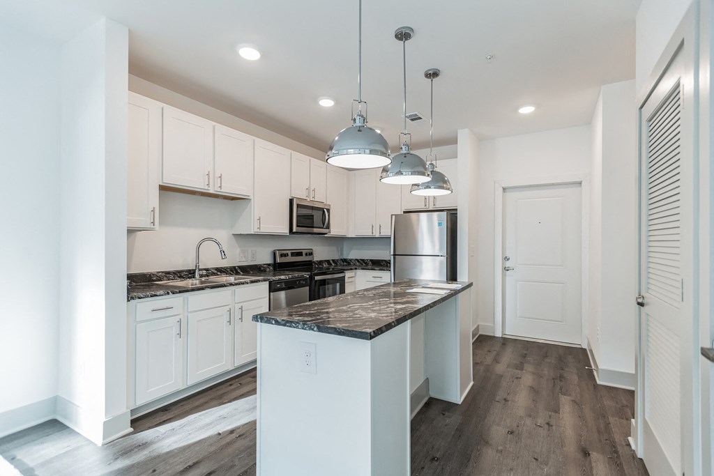 Designer kitchen with white cabinets and pendant lighting