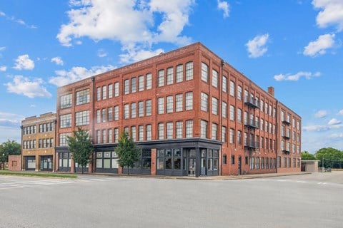 a large brick building with many windows and a street in front