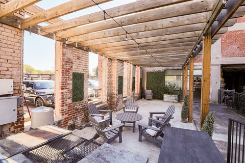 a patio with wooden tables and chairs and a wooden roof