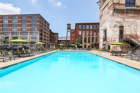a swimming pool with a brick building in the background