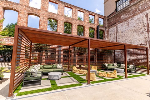 an outdoor patio with green couches and rattan chairs