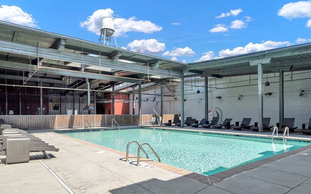 a swimming pool in the middle of a building with chairs