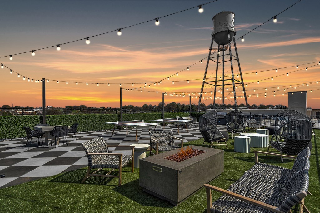 a rooftop restaurant with a water tower at sunset