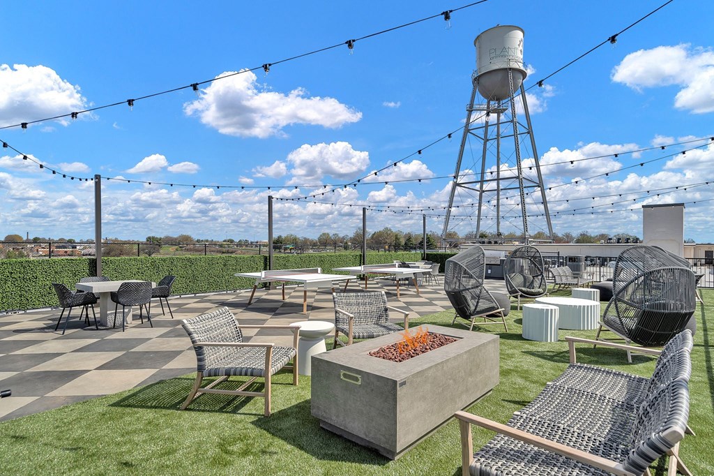 a rooftop patio with tables and chairs and a water tower