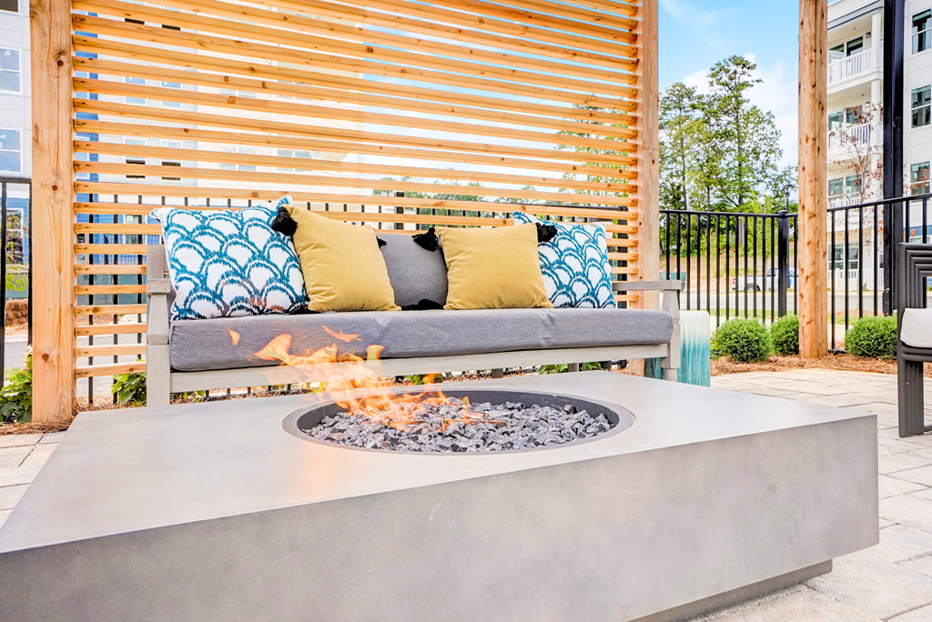 a fire pit on a patio with a wooden privacy fence