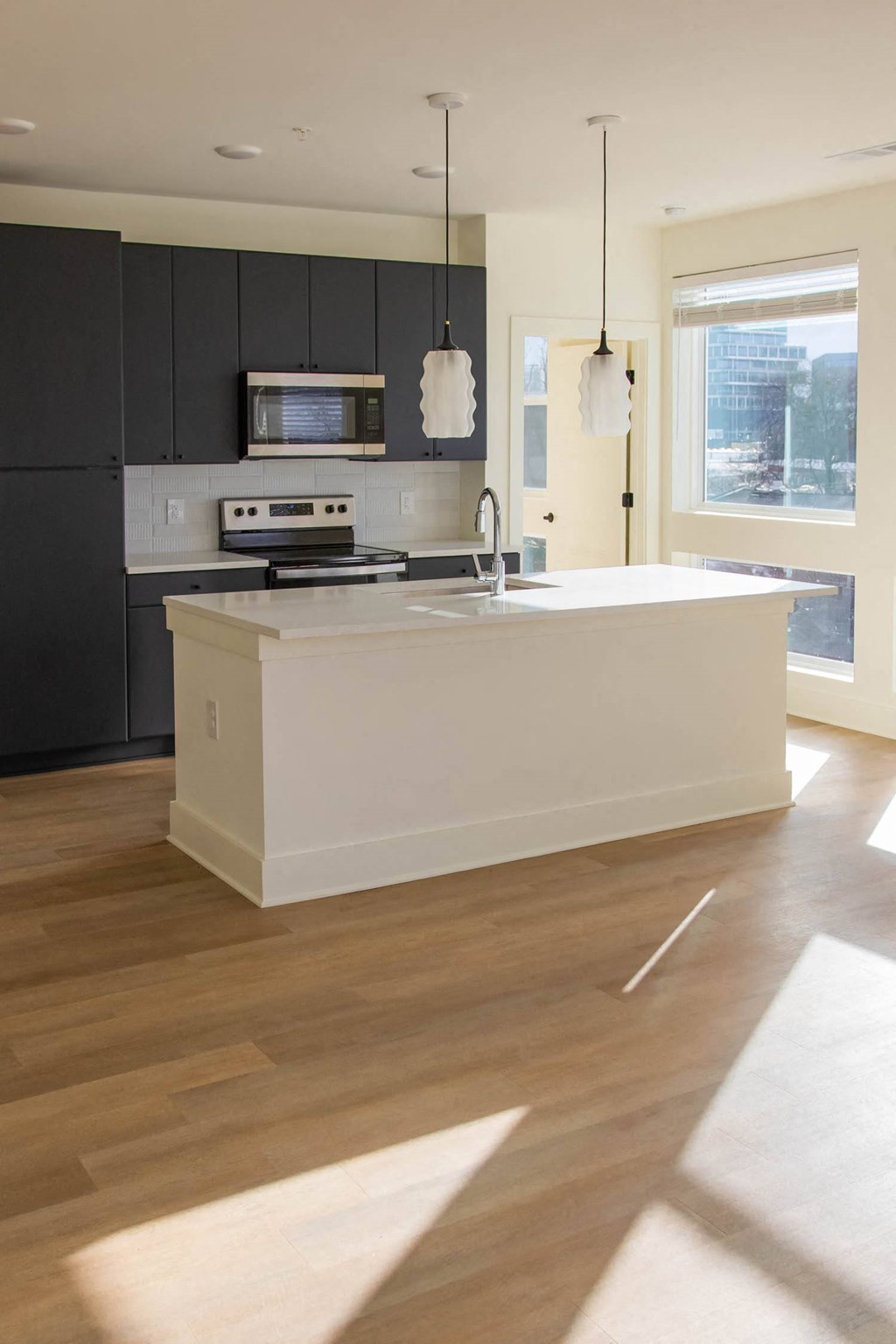 a large kitchen with a white island and black cabinets