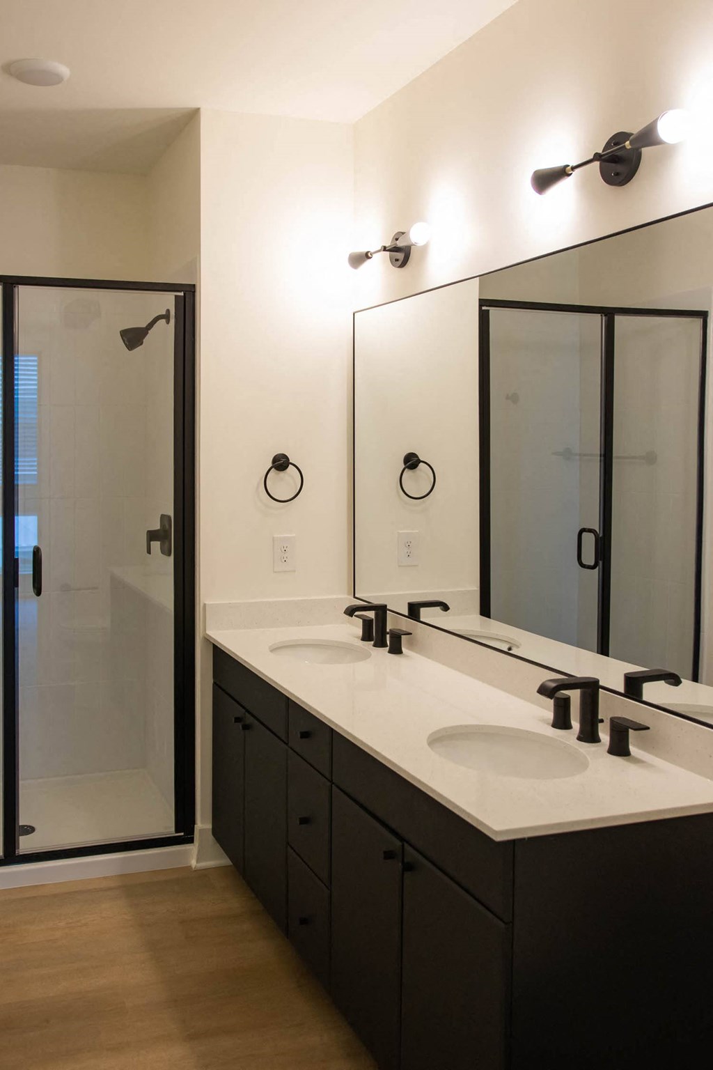 a black and white bathroom with two sinks and a shower
