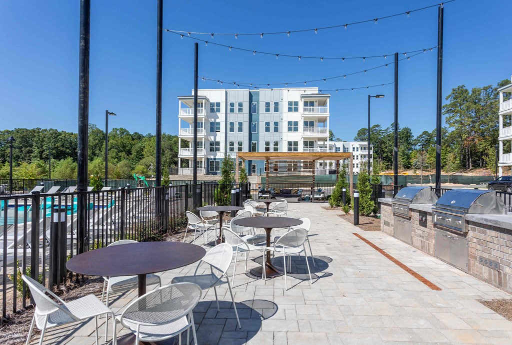 a patio with tables and chairs and a swimming pool