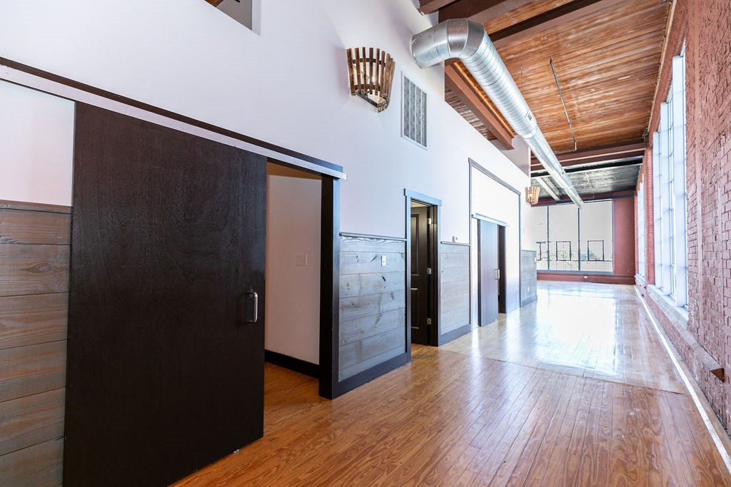 a large room with wood floors and black doors