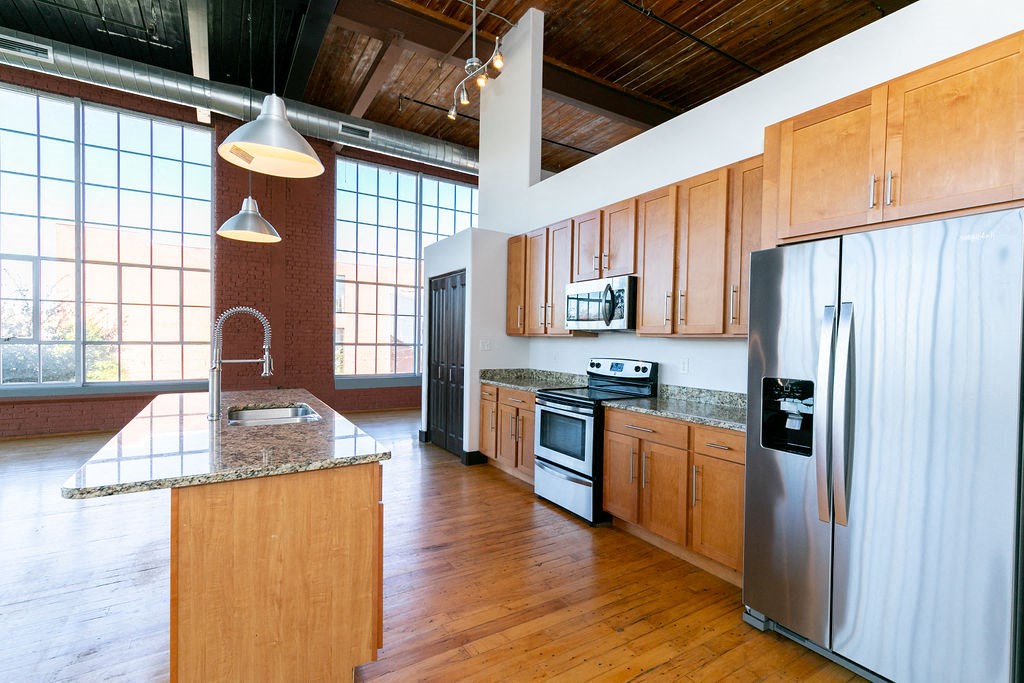 a large kitchen with wooden cabinets and stainless steel appliances