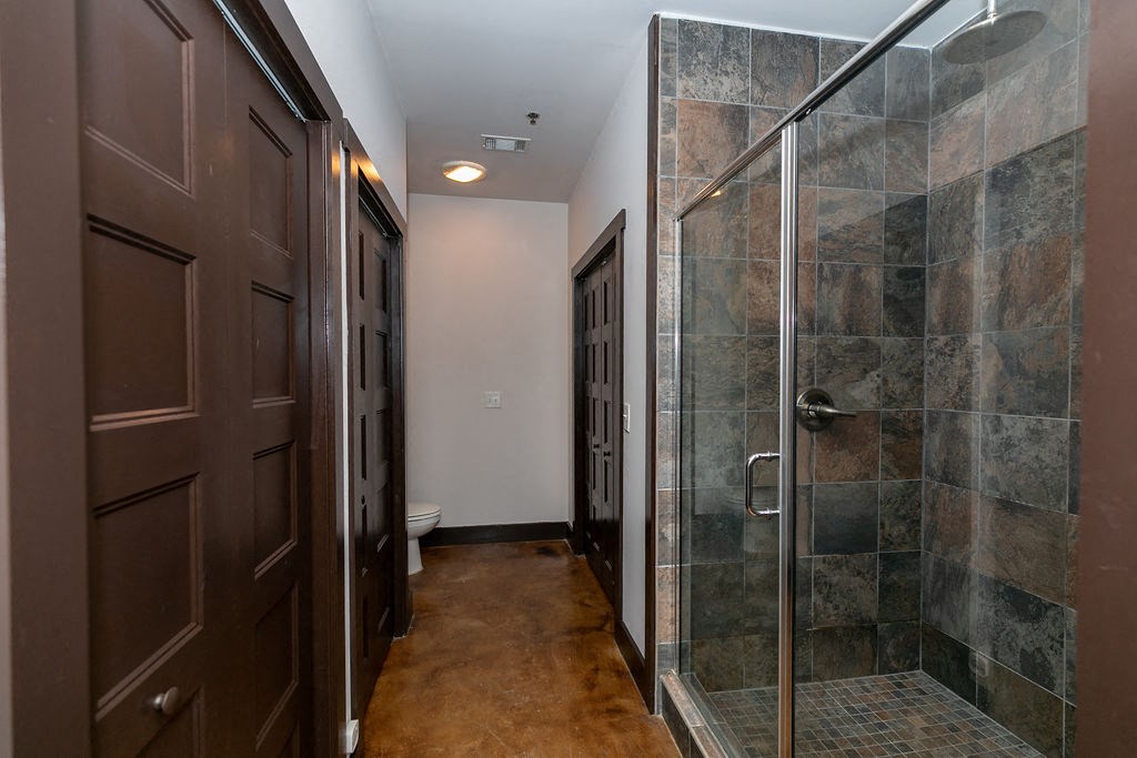 a bathroom with a shower and a brown door