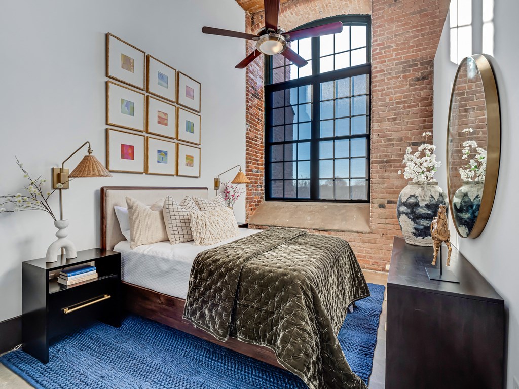 a bedroom with a bed and a ceiling fan