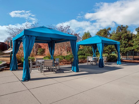a group of blue gazebos with chairs and tables under them