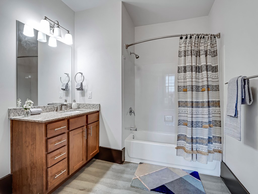 a bathroom with a shower and a sink and a mirror