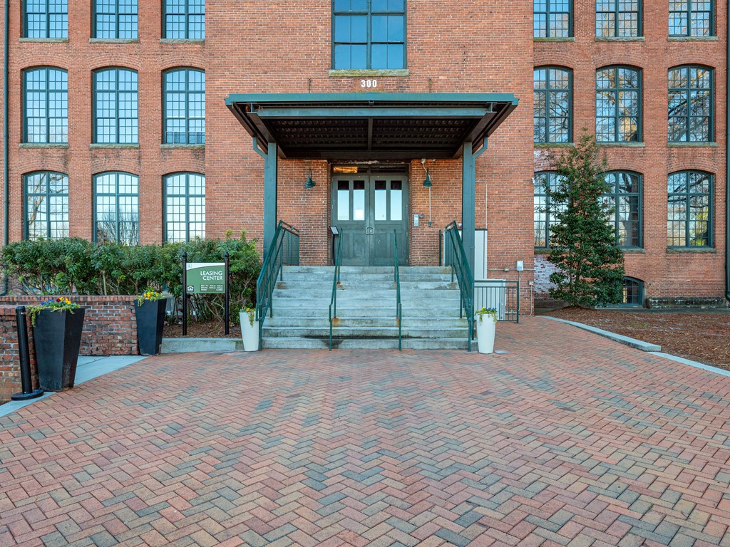 the front of a brick building with stairs and a door