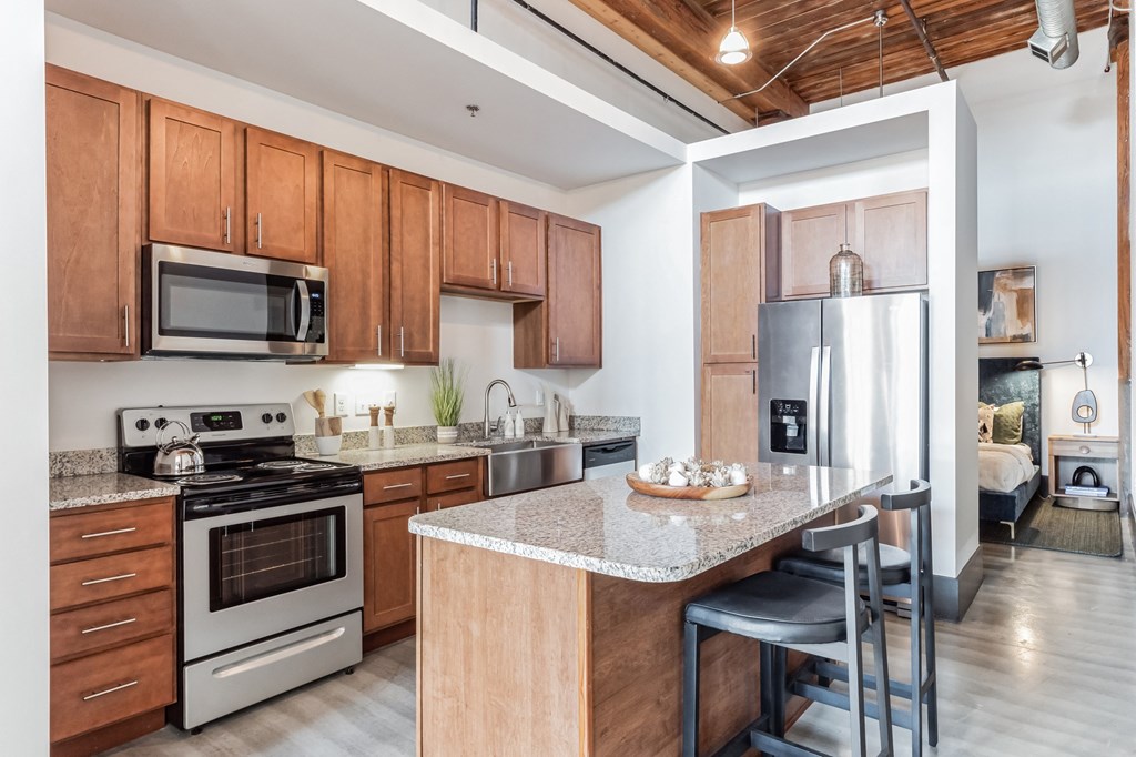 a kitchen with wooden cabinets and stainless steel appliances and a granite counter top
