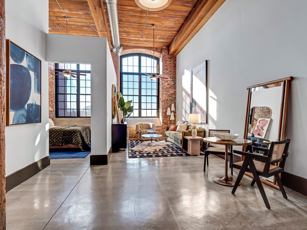 a living room with a large window and a table with a mirror