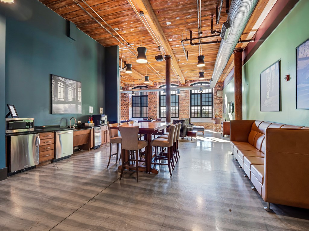 a dining room with a table and chairs and a kitchen in the corner