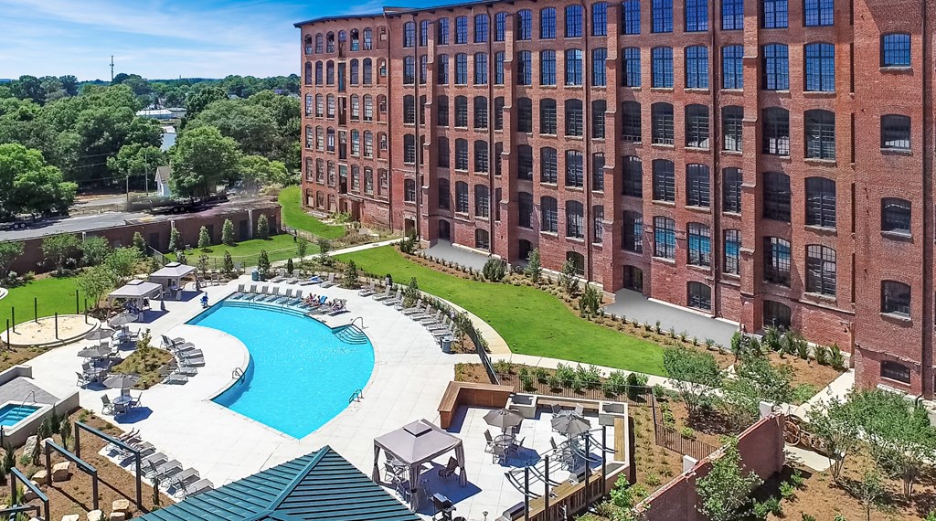 an aerial view of a large brick building with a large pool in front of it
