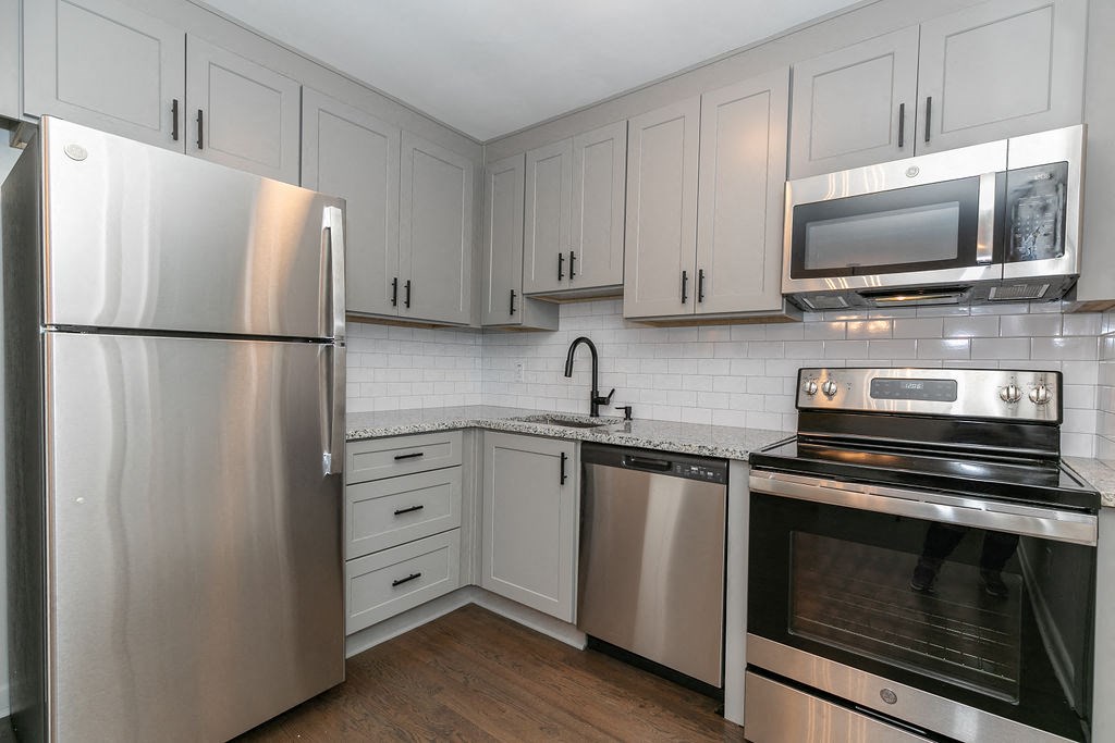 a kitchen with white cabinets and stainless steel appliances
