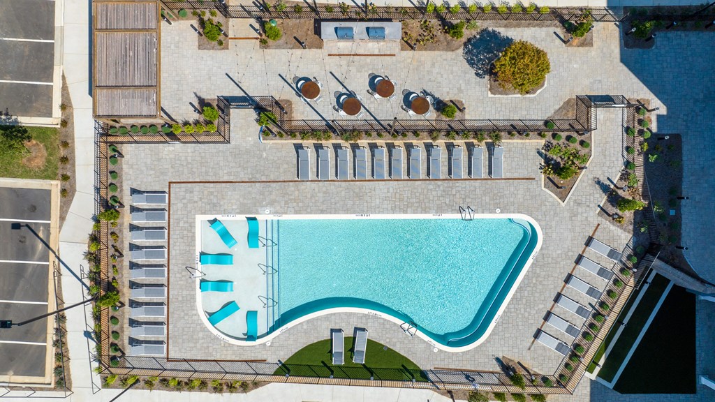 an aerial view of a swimming pool in the middle of a hotel yard
