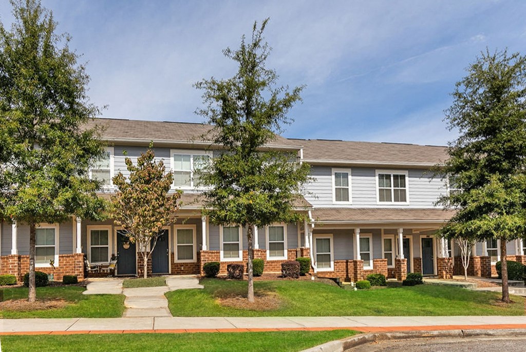 an apartment building with trees in front of it