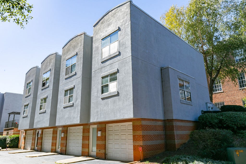 the exterior of an apartment building with a row of garage doors