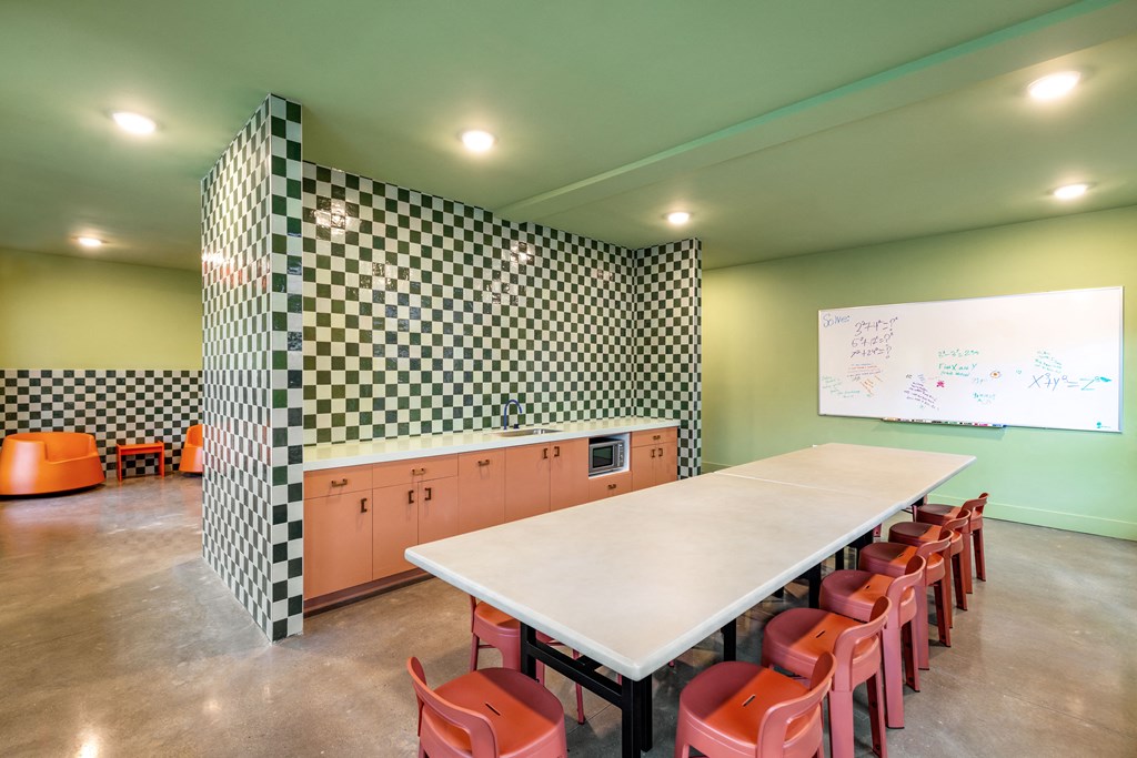 a classroom with a long table and chairs and a whiteboard