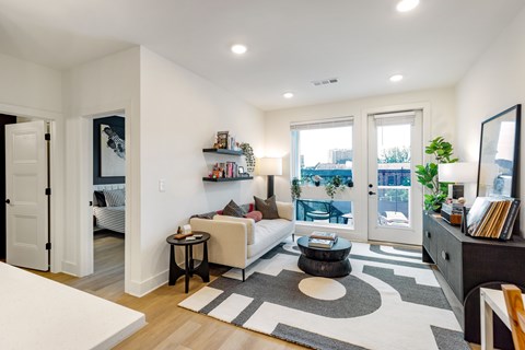 a living room with a couch and a door to a balcony