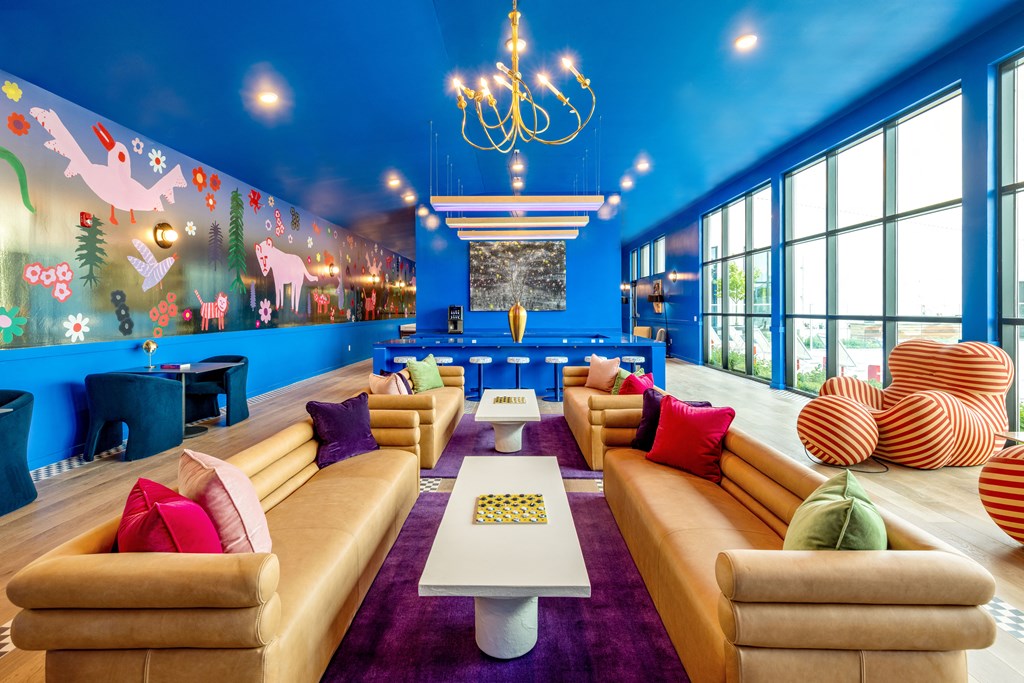 a lounge area with couches and tables and a large wall mural